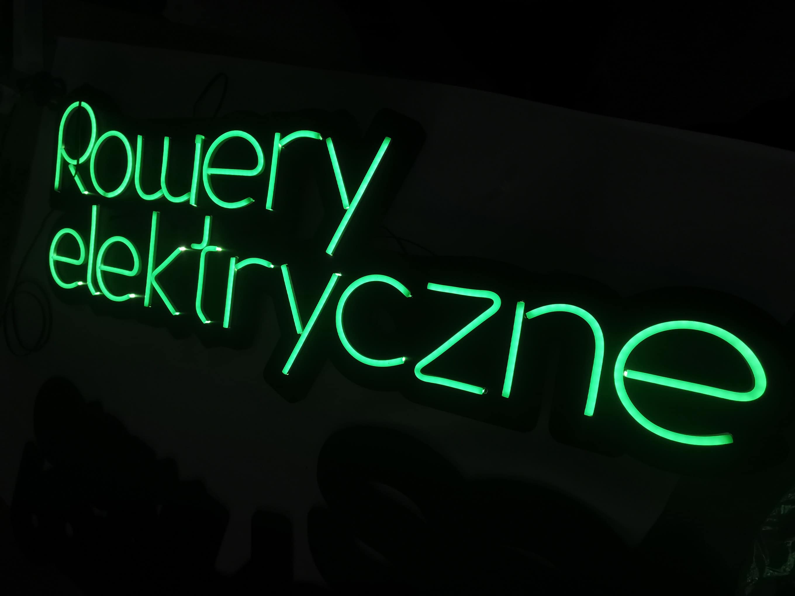 zielony neon na zamówienie - przedstawia napis "rowery elektryczne" - zamówiła go firma z warszawy