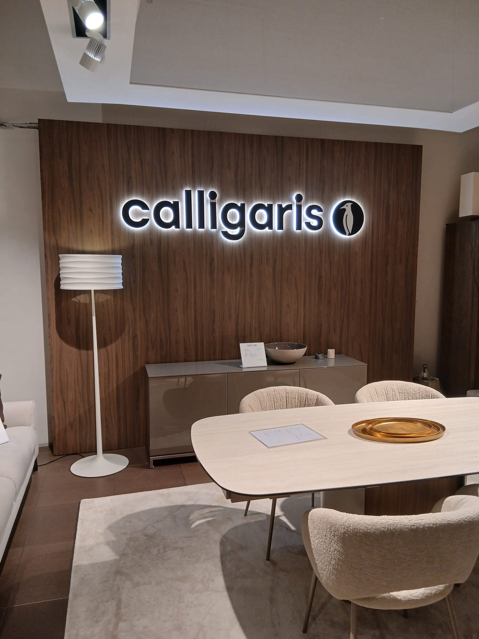 Logo Calligaris na ścianie z drewnianą okładziną i podświetleniem halo